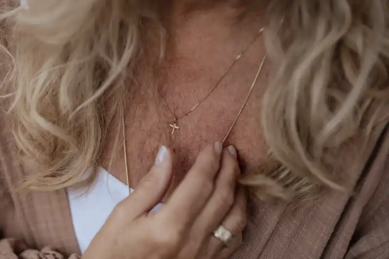 Person in Andacht mit Goldkette und Kreuz hand und Ring